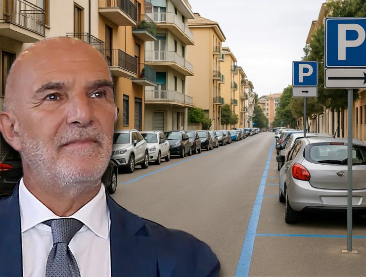 Il Sindaco di Pescara durante la comunicazione sulle nuove tariffe della sosta, con sfondo di strada urbana con strisce blu e parcheggi.