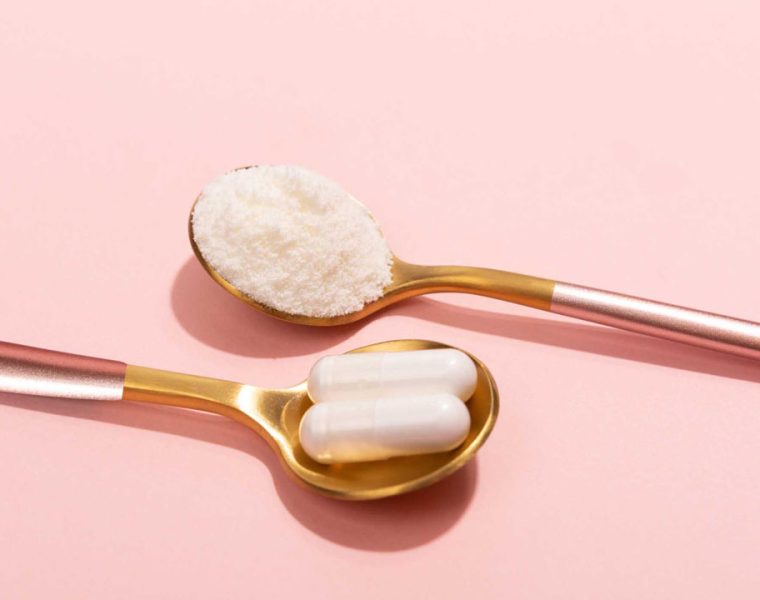 Collagene da bere in polvere e capsule su cucchiai dorati