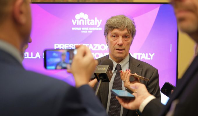 Intervista durante la presentazione di Vinitaly 2026 con logo sullo sfondo e media presenti