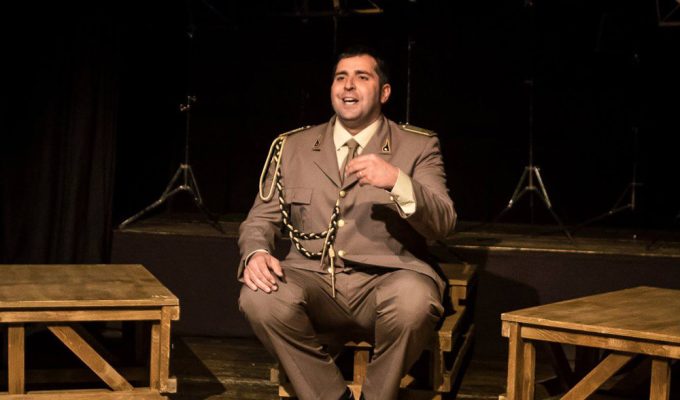 Federico Perrotta a Civitella teatro in scena seduto durante lo spettacolo La Banda