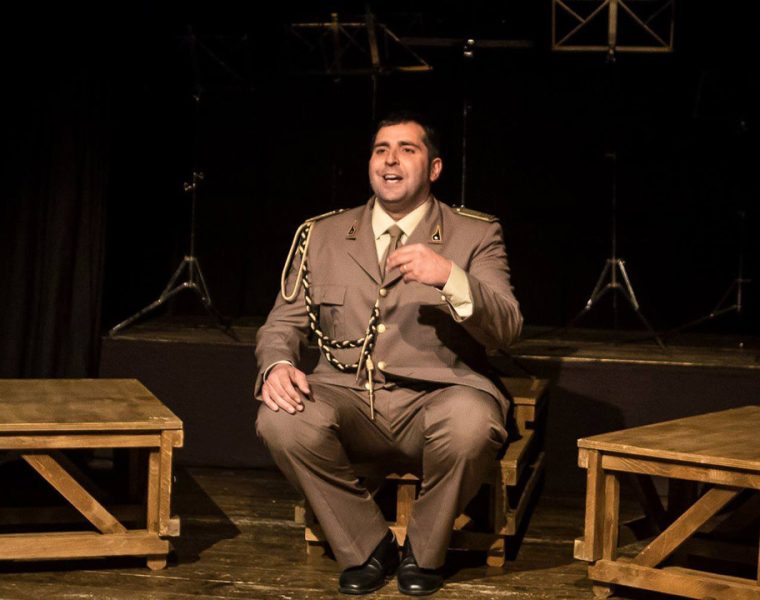 Federico Perrotta a Civitella teatro in scena seduto durante lo spettacolo La Banda