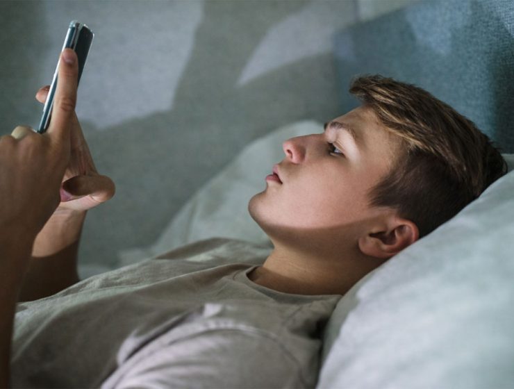 ragazzo sdraiato usa smartphone di notte luce schermo volto social instagram cambia tutto