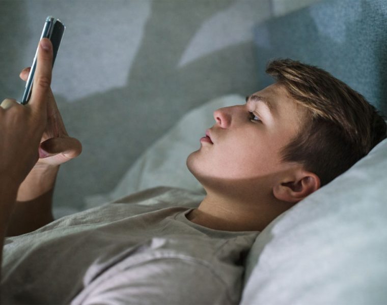 ragazzo sdraiato usa smartphone di notte luce schermo volto social instagram cambia tutto