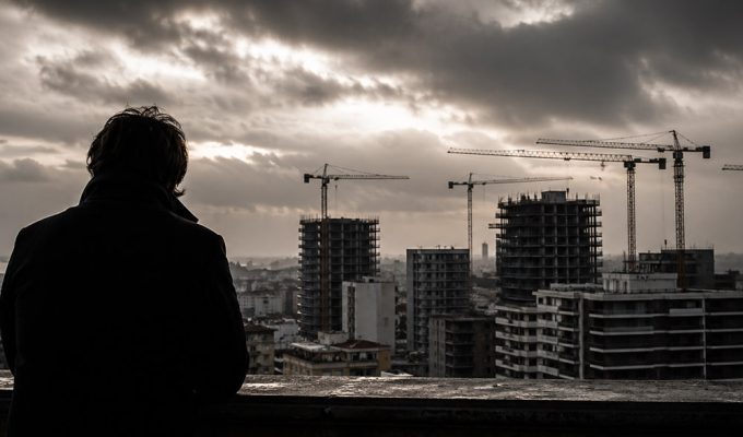 Urbanistica oscura a Pescara con cantieri e gru sullo skyline urbano sotto un cielo scuro