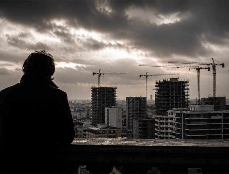 Urbanistica oscura a Pescara con cantieri e gru sullo skyline urbano sotto un cielo scuro