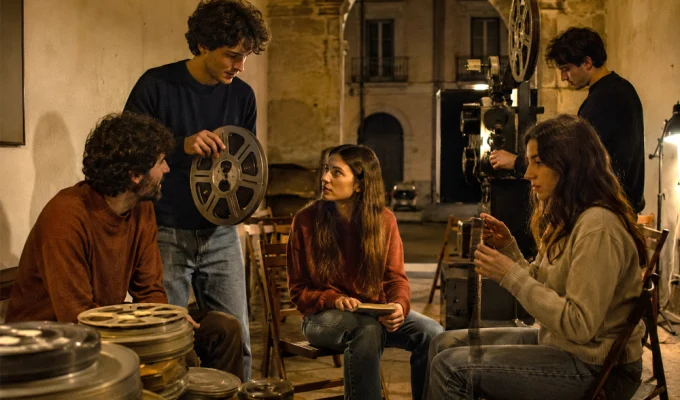 Giovani appassionati di cinema riuniti tra bobine e proiettore in un cineclub d’epoca
