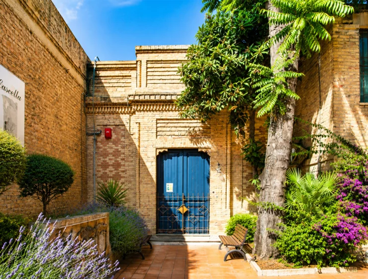 Cascella nelle dimore storiche, cortile del Museo Civico Basilio Cascella di Pescara con porta blu e giardino.