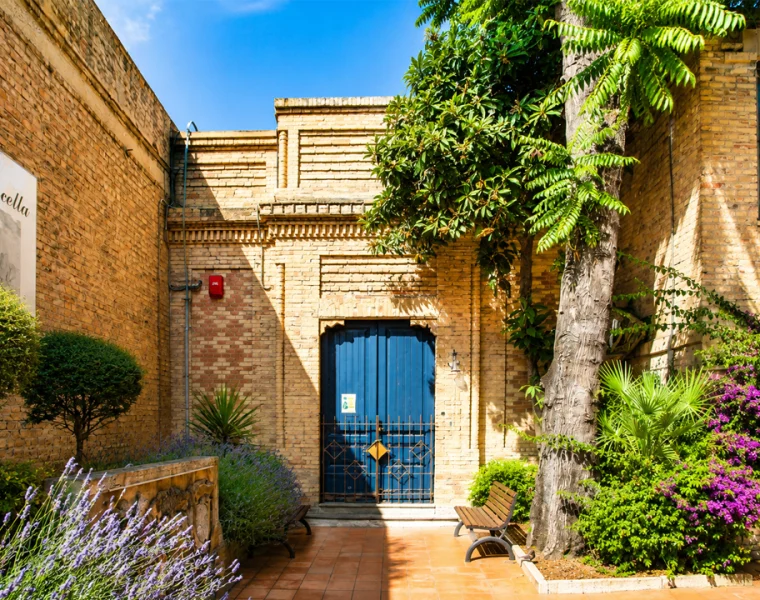 Cascella nelle dimore storiche, cortile del Museo Civico Basilio Cascella di Pescara con porta blu e giardino.