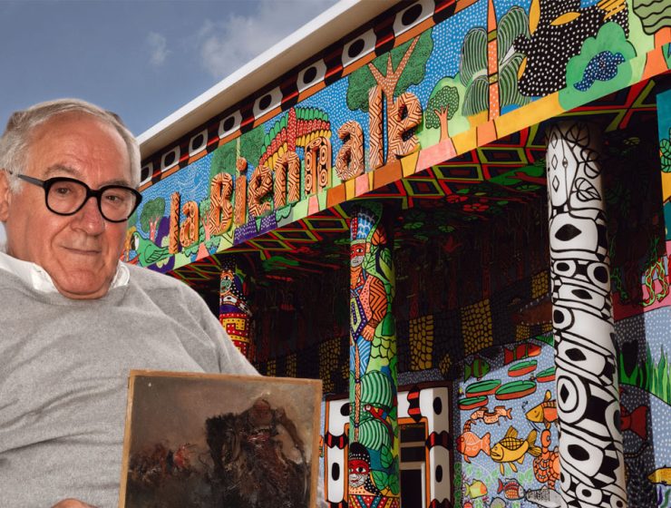 Leo Strozzieri racconta la Biennale davanti a un padiglione colorato con la sua opera tra le mani