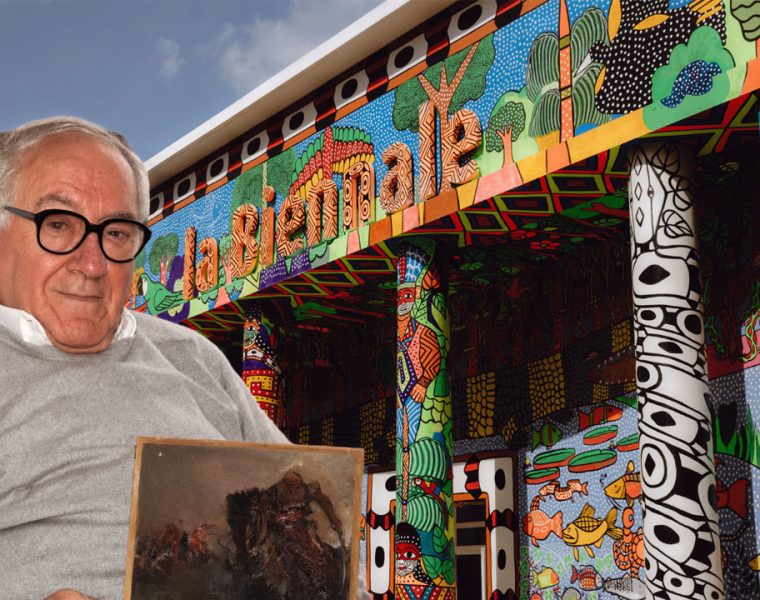 Leo Strozzieri racconta la Biennale davanti a un padiglione colorato con la sua opera tra le mani