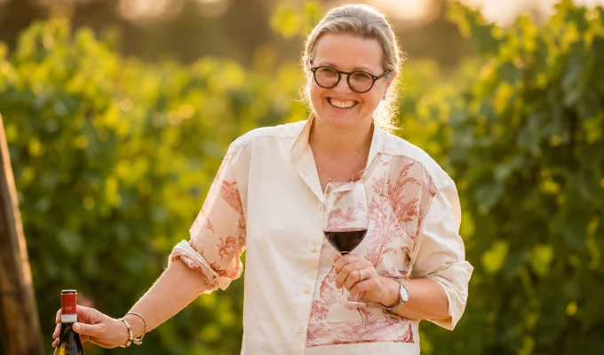 Marina Cvetic Cavaliere del Lavoro sorridente tra le vigne con un calice di vino