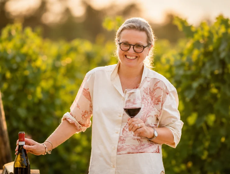 Marina Cvetic Cavaliere del Lavoro sorridente tra le vigne con un calice di vino