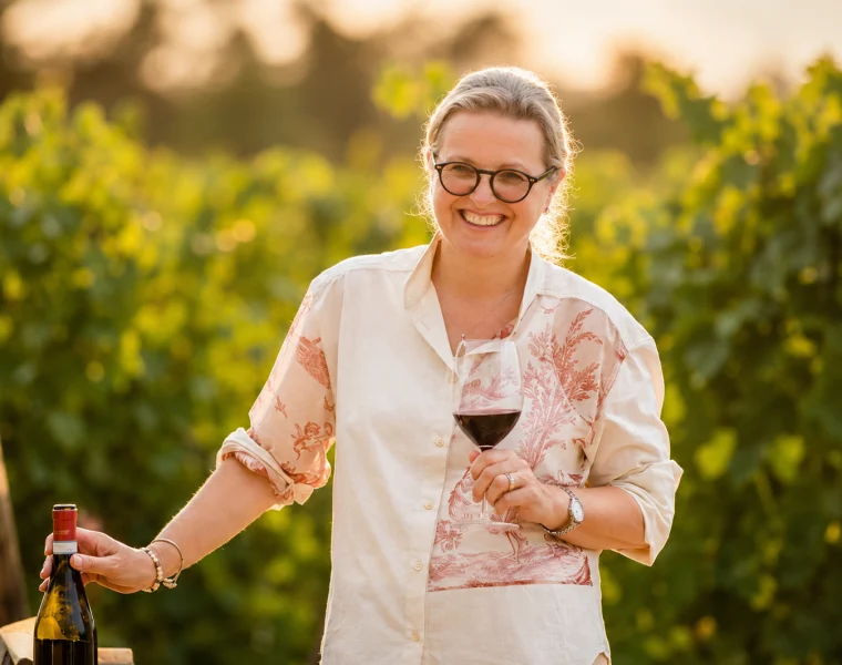 Marina Cvetic Cavaliere del Lavoro sorridente tra le vigne con un calice di vino