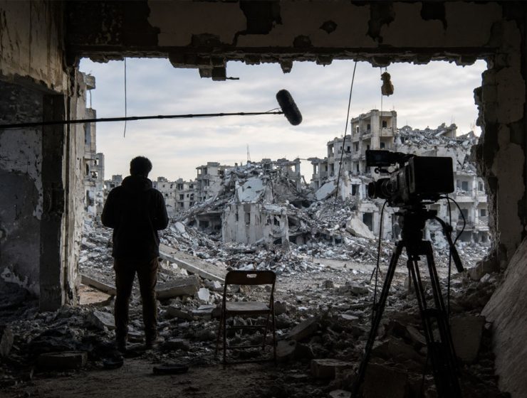Venice4Palestine boicottaggio cinema italiano, scena cinematografica tra rovine urbane e telecamera.