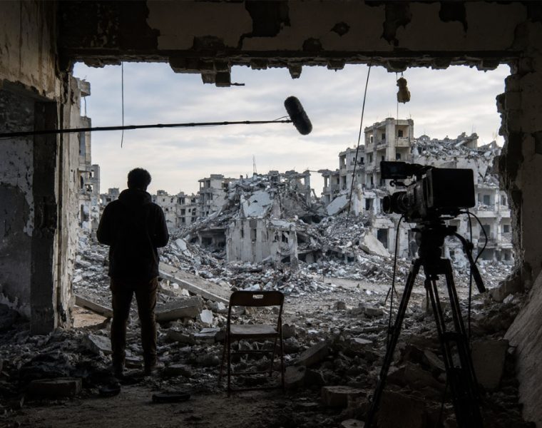 Venice4Palestine boicottaggio cinema italiano, scena cinematografica tra rovine urbane e telecamera.